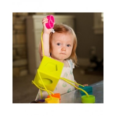 Oombee atradimų kubas kūdikiams ir lavinamąjį žaislą laikanti mergaitė