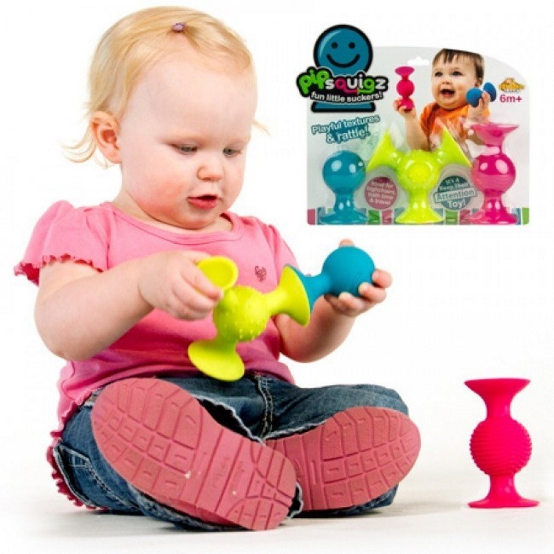 Fat Brain PipSquigz lipšniukai barškučiai - pakuotės vaizdas baltame fone ir sėdintis kūdikis