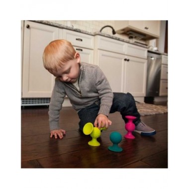 Fat Brain PipSquigz lipšniukai - barškučiai prilipinti prie grindų ir šalia žaidžiantis berniukas