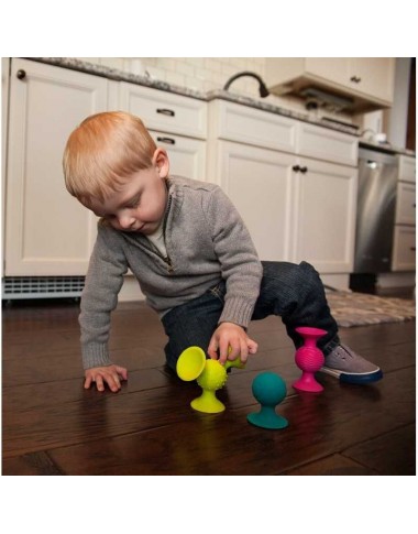 Fat Brain PipSquigz lipšniukai barškučiai - pakuotės vaizdas baltame fone ir sėdintis kūdikis