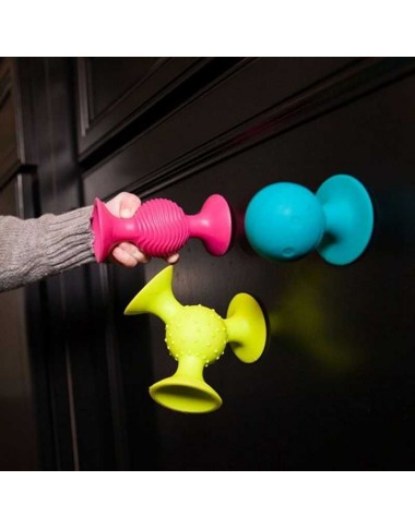 Fat Brain PipSquigz lipšniukai barškučiai - pakuotės vaizdas baltame fone ir sėdintis kūdikis