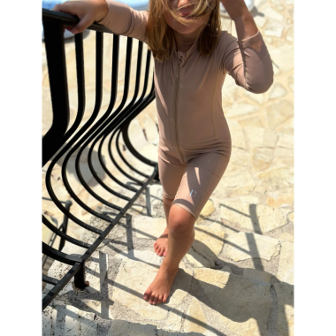 Einanti mergaitė su rudu maudymosi kostiumėliu vaikams