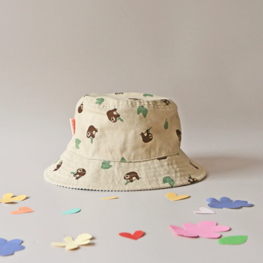 Dvipusė vasarinė kepurė vaikams Tinginys padėta ant stalo