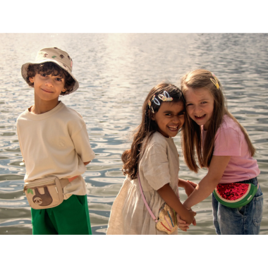 Vaikų būrys, vienas berniukas dėvi dvipusė vasarinę kepurę vaikams