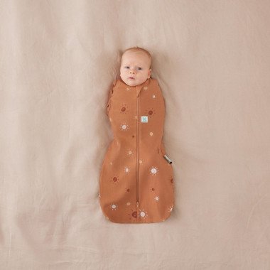Galintis kūdikis su ergoPouch Swaddle miegmaišiu kūdikiui su saulytemis 0.2TOG (3-6 mėn.) ir paslėptomis rankytėmis