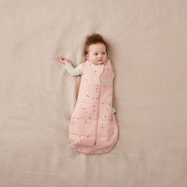 ergoPouch Swaddle miegmaišis kūdikiui 2.5TOG (6-12 mėn.) su vaiku, kuris iškišęs vieną rankytę