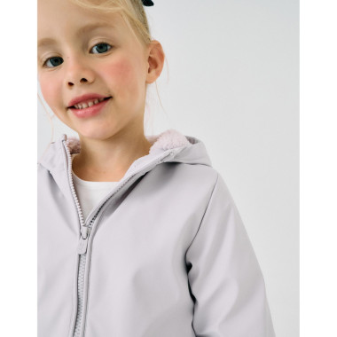 Mergaitė dėvinti alyvinę Zippy lietaus striukę