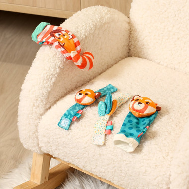 Ludi pėdų ir rankų barškučių rinkinys  sudėtas ant fotelio