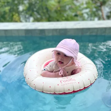 Rausva maudymosi kepurė nuo saulės UPF 50+ (0-2 m.) ir mergaitė baseine