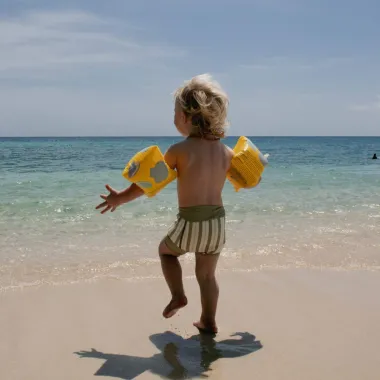 Pripučiamos plaukimo rankovės (2-6 m) ir bėgantis vaikas