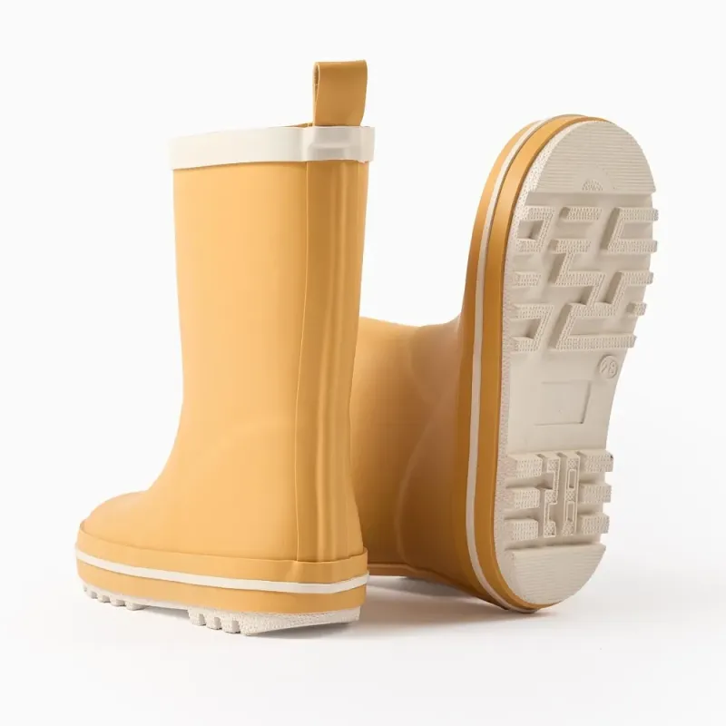 Geltoni vaikiški guminiai batai (25-32) - vienas batas pakeltas, matosi neslystantis padas Geltoni vaikiški guminiai batai (25-32) - vienas batas pakeltas, matosi neslystantis padas