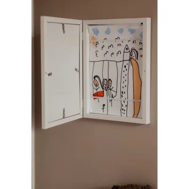 Vaikų piešinių atidaromas rėmelis - vaizdas iš arčiau ant rudos sienos, atidarytas