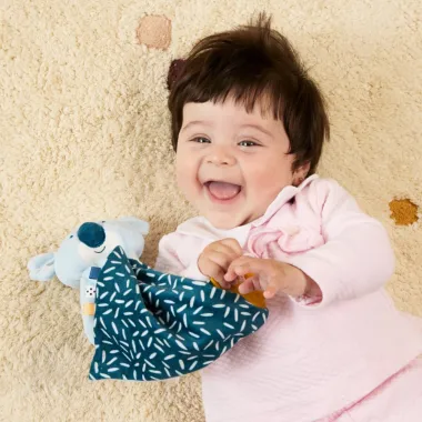 Mergaitė žaidžia su Miniland migduku kūdikiams Koala