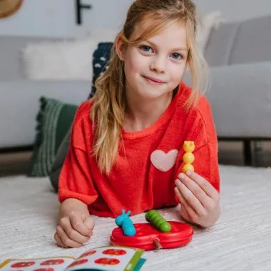 Mergaitė sprendžia galvosūkį Smart Games Apple Twist