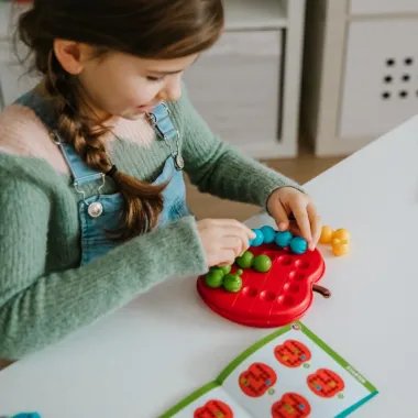 Mergaitė žaidžia su loginiu žaidimu Apple Twist