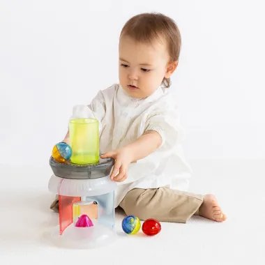 Berniukas žaidžia su kamuoliuku bokšteliu - 1curiosity lavinamasis žaidimas Karuselė