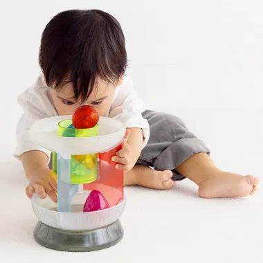 Berniukas rankytėmis negrinėja 1curiosity lavinamąją kamuoliukų Karuselę