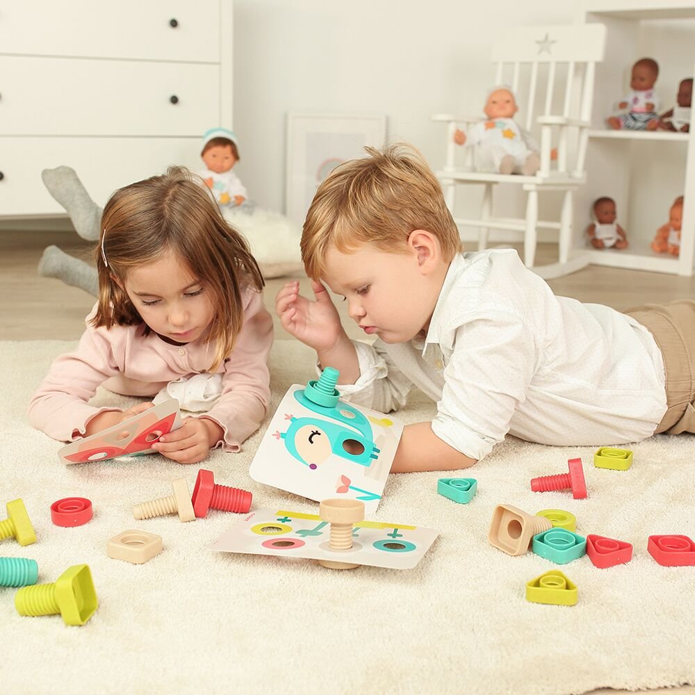 Vaikai žaidžia su lavinamuoju žaislu ant grindų, skatinamas kūrybiškas ir savarankiškas žaidimas